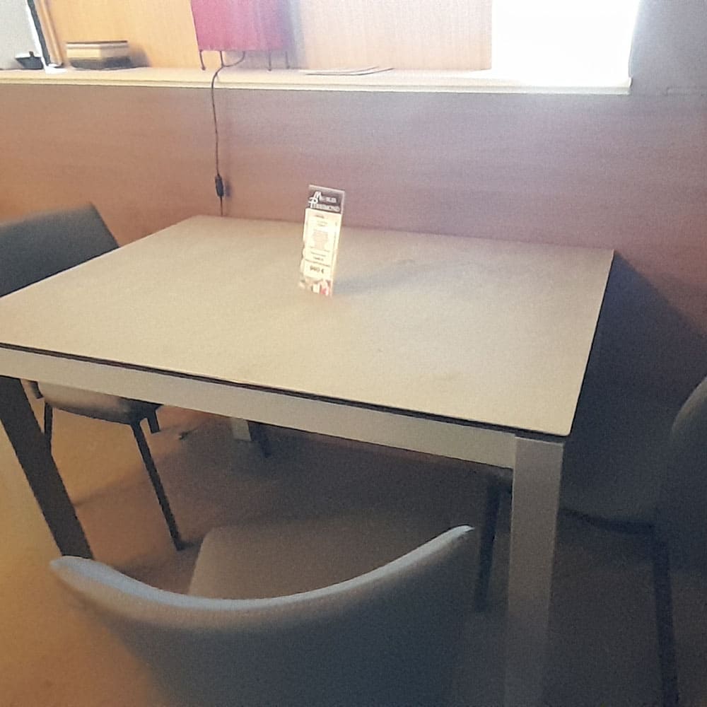 Table-blanche-collé-à-un-mur-avec-3-chaises-autour